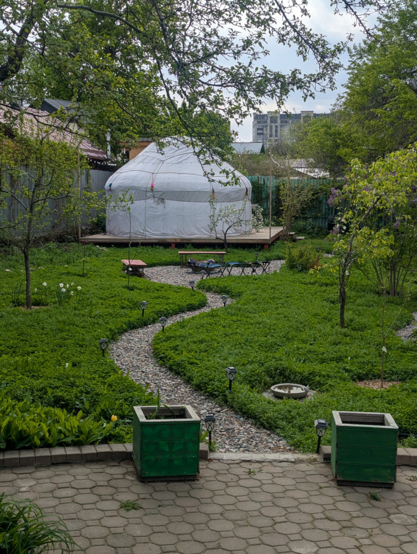 Yurt39 in the spring garden — stone path, apple trees